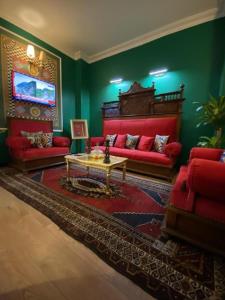 a living room with red furniture and green walls at THINK HOTEL in Konya