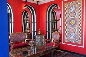 Habitación con 2 sillas y pared roja. en THINK HOTEL en Konya