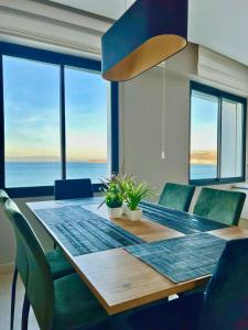 a dining room table and chairs with a view of the ocean at The Mirage Tangier - 3BR Luxury Sea View with Private Hammam & Jacuzzi in Tangier