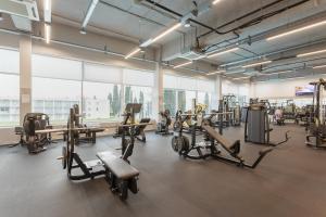 a gym with several treadmills and cardio machines at Спорт инн отель и спа in Adler