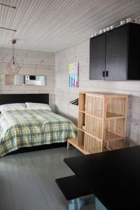 1 dormitorio con 1 cama, armarios y mesa en Ihana järvenranta mökki. Cottage by the lake., en Kurjalanranta