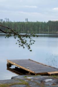 un muelle de madera sobre un lago en Ihana järvenranta mökki. Cottage by the lake., en Kurjalanranta
