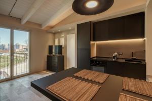 una cocina con armarios negros y una gran ventana en Baciucco's Suite, en Perugia