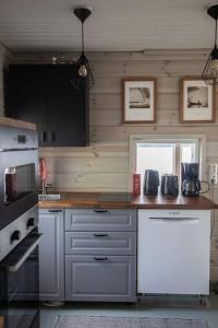 a kitchen with white appliances and a counter top at Ihana järvenranta mökki. Cottage by the lake. in Kurjalanranta