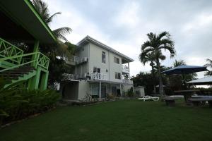 a large white house with an umbrella and a yard at The Perfect Suite B in Playa Hermosa