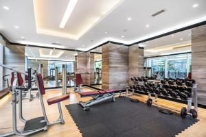 Spacious Studio In Business Bay في دبي: غرفة ممارسة مع أجهزة ركض وأوزان