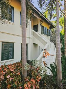 a person standing on a staircase in front of a house at Villa Maly Boutique Hotel in Luang Prabang