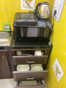 a microwave oven sitting on top of a kitchen counter at Spacious Studio & Pool facility. in Benaulim