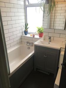 a bathroom with a bath tub and a sink at Abingdon Cosy Nest in Sunningwell