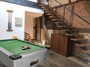 a room with a pool table and a staircase at Au billot Chanteloup in Charlieu