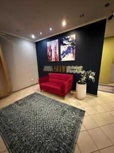 een woonkamer met een rode bank en een tapijt bij AlmaPort in Talghar