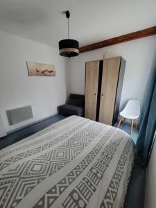 1 dormitorio con 1 cama y 1 silla en Maison region de Domme, en Saint-Martial-de-Nabirat