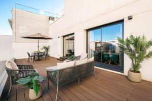 taras na świeżym powietrzu z krzesłami, parasolem i stołem w obiekcie Feelathome Goya Apartments w Madrycie