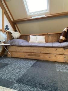 a wooden bed in a room with a window at Vakantie-Appartement WedderheideHoeve in Wedde
