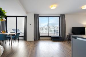 - un salon avec une table, des chaises et des fenêtres dans l'établissement Feelathome Goya Apartments, à Madrid