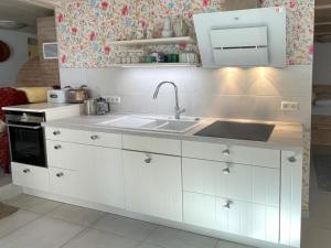 a kitchen with white cabinets and a sink at Albliebe am Rosenbühl in Münsingen