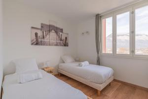 a bedroom with two beds and a window at R'Apparts T4 Les Balcons De Belledonne in Rhut