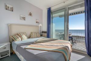 une chambre avec un lit et un balcon dans l'établissement Échappée à 4 - Superbe vue mer - 30m de la plage, à La Baule