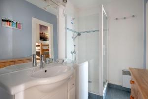 une salle de bain blanche avec un lavabo et une douche dans l'établissement Échappée à 4 - Superbe vue mer - 30m de la plage, à La Baule