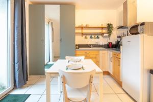 cocina con mesa blanca y sillas blancas en Studio 3 Oisans - Terrasse et parking privé, en Meylan