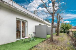 Casa blanca con mesa y sillas en el patio en Studio 4 Vercors - Terrasse et parking Privé, en Meylan