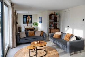 Una sala de estar con dos sofás y una mesa. en 8 persons waterfront Villa, en Roelofarendsveen