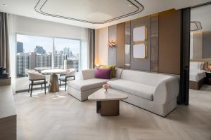 曼谷的住宿－帕色哇公主酒店【SHA Extra Plus】，客厅配有沙发和桌子