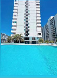 a large swimming pool in front of a tall building at Seaside Serenity in San Juan