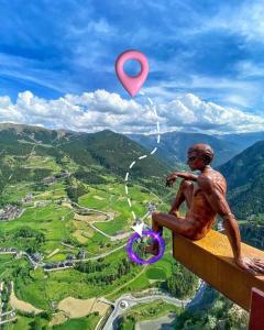 a statue of a man sitting on a ledge with a target at UNIQUE 57m2 Terraza BBQ magica vista Quer in Canillo