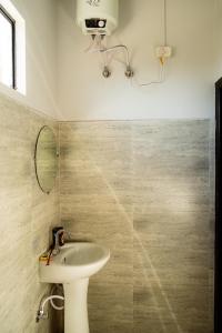 ein Bad mit einem Waschbecken und einem Spiegel in der Unterkunft Solo's Inn in Kohīma