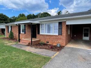 a home with a brick house with a driveway at 1 king/2queen bd home next to big park in Lexington