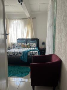 - une chambre avec un lit, une chaise et une fenêtre dans l'établissement A Cheerful Furnished Bedroom Retreat, à Johannesbourg