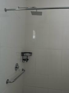 La salle de bains est pourvue d'une douche et de carrelage blanc. dans l'établissement A Cheerful Furnished Bedroom Retreat, à Johannesbourg
