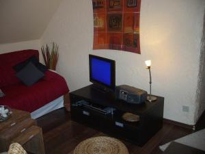 ein Wohnzimmer mit einem TV und einem Sofa in der Unterkunft Voßhörn 27, Ferienwohnung 4 in Cuxhaven