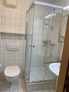ein Bad mit einer Dusche, einem WC und einem Waschbecken in der Unterkunft Elbe I, Ferienwohnung 29 in Cuxhaven