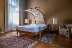 1 dormitorio con cama con dosel y silla en Il Castello Di San Gaudenzio, en Cervesina