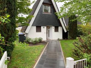 een klein wit huis met een gambrel dak bij Kampweg 18 in Cuxhaven