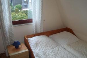 een kleine slaapkamer met een bed en een raam bij Kampweg 18 in Cuxhaven
