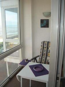 een kamer met een tafel, een stoel en een raam bij Seehütte Ferienwohnung 306 in Cuxhaven