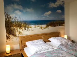 um quarto com uma cama e uma pintura da praia em Seeadler, Ferienwohnung 4 em Cuxhaven