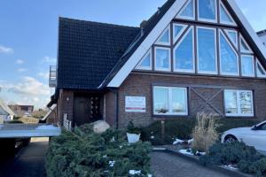 une maison avec un toit en gambrel dans l'établissement Haus Dwarslöper, Ferienwohnung 2, à Cuxhaven