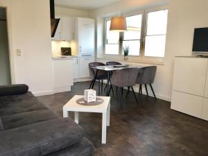 a living room with a couch and a table at Villa Döser Strand in Cuxhaven