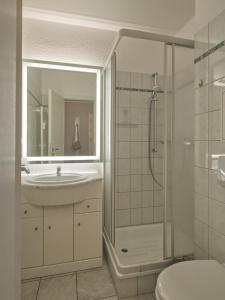 a bathroom with a sink and a shower and a toilet at Villa Döser Strand in Cuxhaven