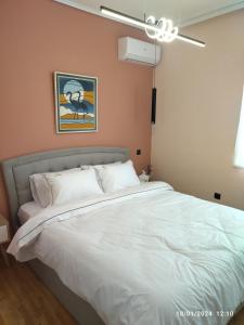 a bedroom with a large white bed with a ceiling fan at Swan Paradise Glyfada Apartment in Athens