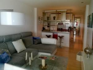 a living room with a couch and a kitchen at Precioso Duplex Reina Mercedes 5 minutos Hospital in Seville