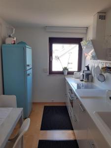 a kitchen with a blue refrigerator and a window at Ferienapartment Ida in Lorch