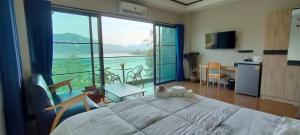 una camera da letto con un letto grande e una grande finestra di Turtle Nest a Khao Tao