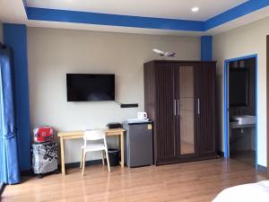 a room with a desk and a television on the wall at Turtle Nest in Khao Tao