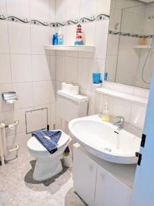 ein weißes Bad mit einem WC und einem Waschbecken in der Unterkunft Seehütte Ferienwohnung 507 in Cuxhaven