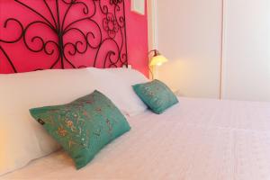 a white bed with two green pillows on it at Apartamento Tartessos in Seville